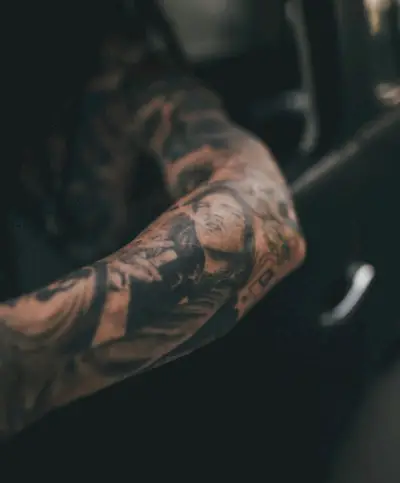 Et detaljeret portræt pryder underarmen, et personligt galleri af minder og øjeblikke fanget med blæk.