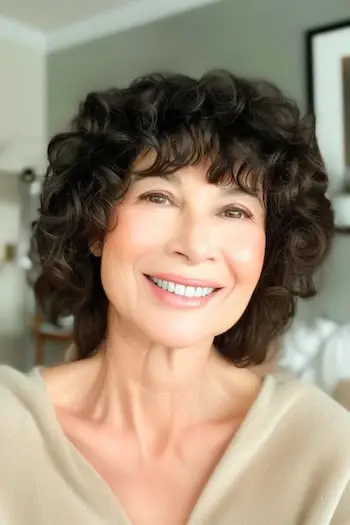 나이든 여성을 위한 앞머리 헤어스타일의 곱슬 레이어.