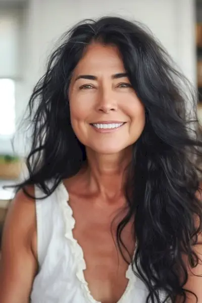 50歳以上の女性のためのフリンジの長いヘアスタイルの乱れたウェーブ。