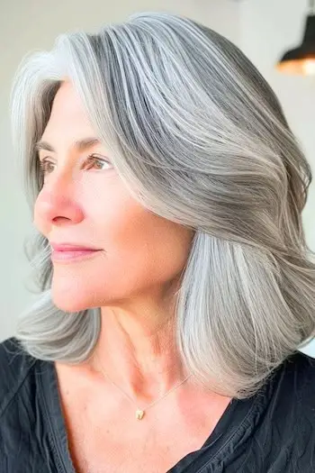 Středně dlouhý lob na ženě ve věku 60 let s šedými vlasy.