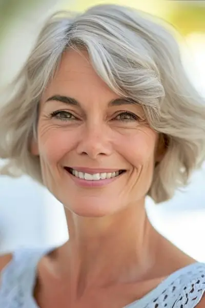 年配の女性の柔らかいカールしたボブのヘアカット。