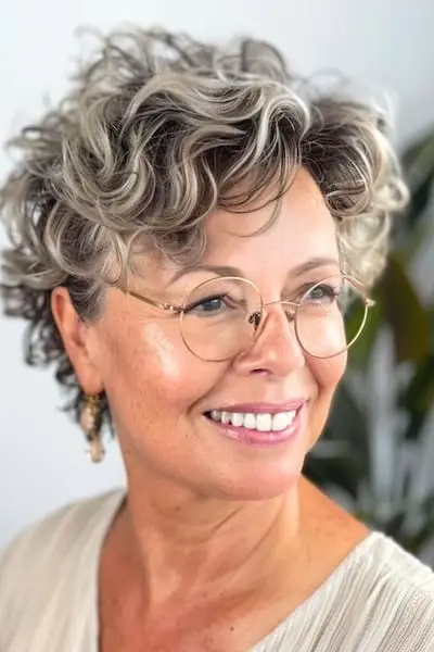 Kort krøllet frisure til kvinder over 40 med briller.