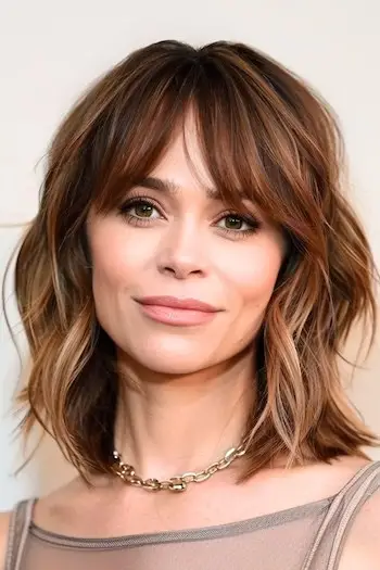 Účes Shaggy Lob s ofinou pro ženy nad 40 let s hustými vlasy.