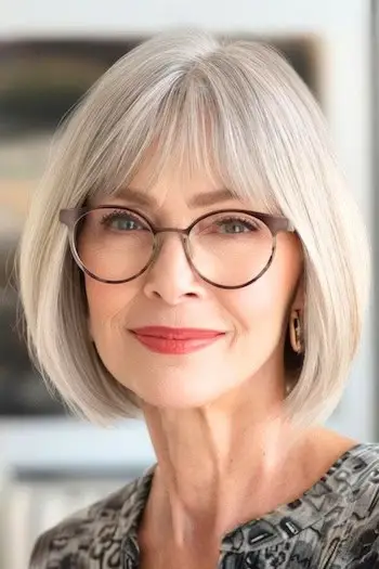Bob s ofinou po bradu Krátký účes pro ženy nad 60 let s brýlemi.