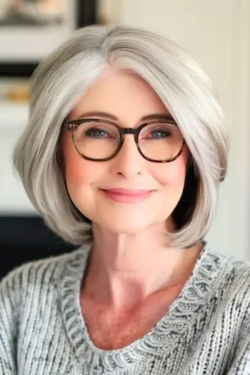 Zaoblený vrstvený Bob krátký účes na starší ženě se stříbrnými vlasy.