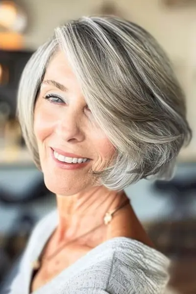 Bob con peinado corto con raya lateral profunda para mujeres mayores de 50 años con cabello fino.