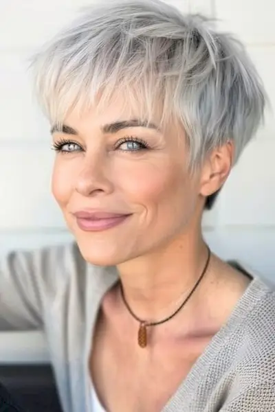 Duendecillo entrecortado con flequillo, peinado corto para mujeres mayores de 50 años con cabello fino.