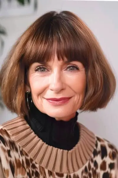 Kastanienbrauner runder Bob mit Pony-Frisur für Frauen über 60.