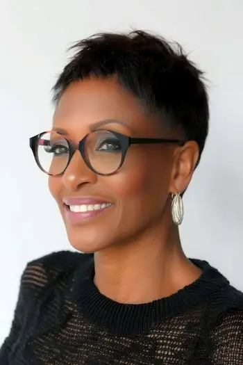 Przycięta fryzura Pixie z wygolonymi bokami Krótka fryzura dla kobiet powyżej 50. roku życia w okularach.