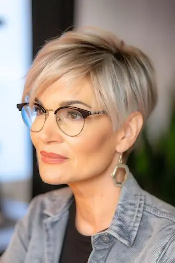 Prosta fryzura Pixie z grzywką na bok Krótka fryzura dla kobiet po 50. roku życia w okularach.