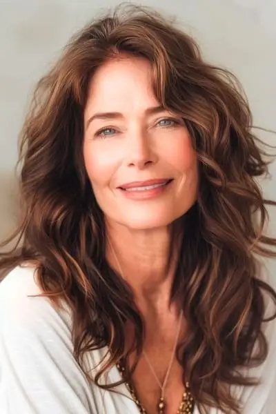 두꺼운 머리를 가진 50세 이상 여성을 위한 긴 웨이브 레이어 헤어스타일.