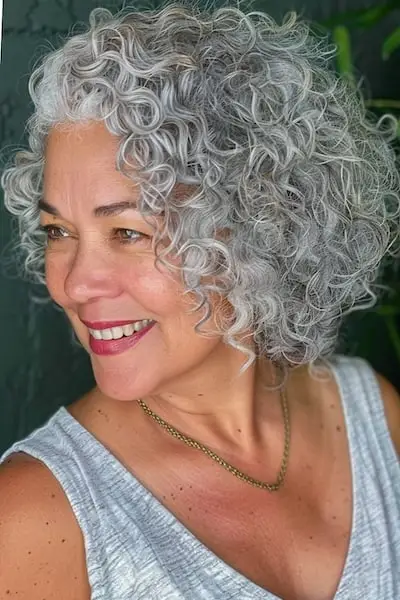 굵은 머리카락을 가진 50세 이상 여성을 위한 소금과 후추 컬 헤어스타일.