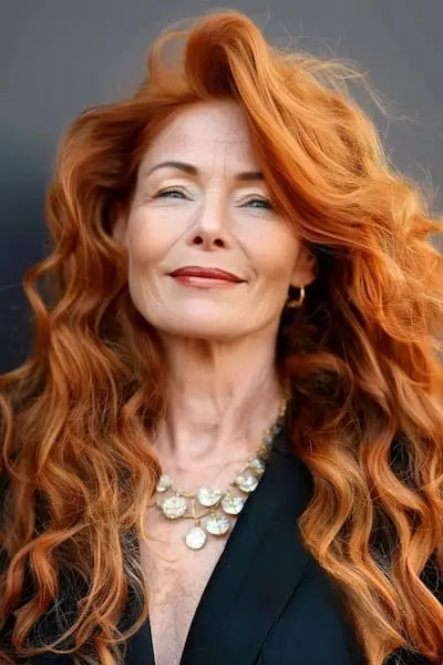 두꺼운 머리카락을 가진 50세 이상 여성을 위한 볼륨감 있는 구리 컬 헤어스타일.