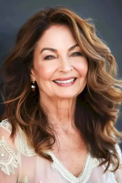 60歳以上の女性のためのウェーブのかかったブローアウトのミディアムレングスのヘアスタイル。