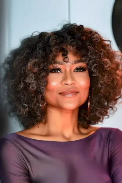 60歳以上の女性のためのボリュームのあるコイルのミディアムレングスのヘアスタイル。