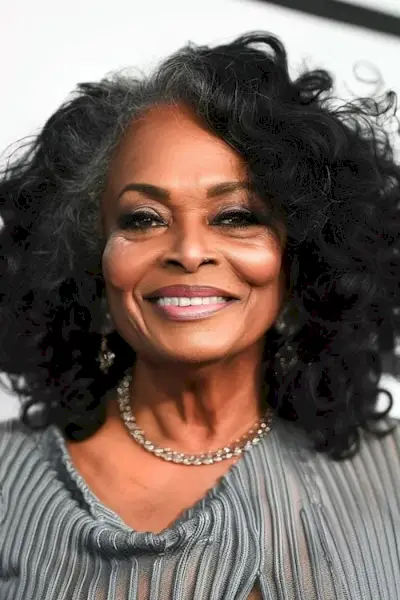 60歳以上の女性のためのレイヤードナチュラルカールのミディアムレングスのヘアスタイル。