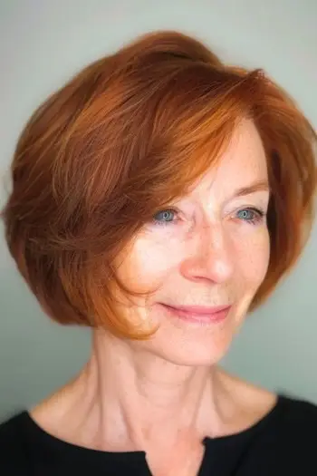 가는 머리를 가진 60세 이상의 여성을 위한 레이어드 구리 밥 짧은 헤어스타일.