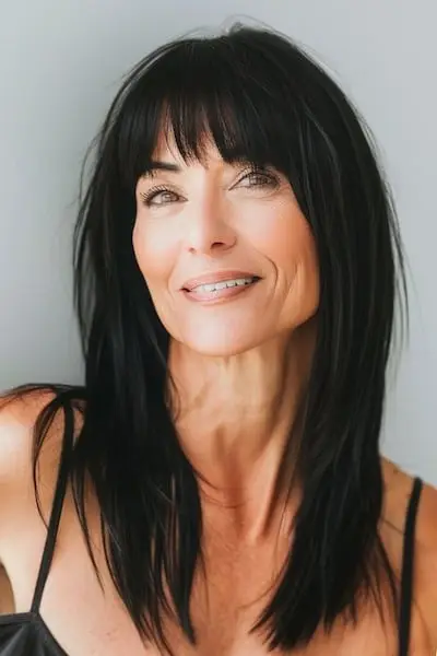 うっすらとした前髪のあるロングストレートヘア 前髪のある50歳以上の女性のためのヘアスタイル。