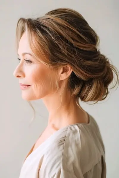 70세 이상 여성을 위한 볼륨감 있고 낮은 시뇽 헤어스타일.