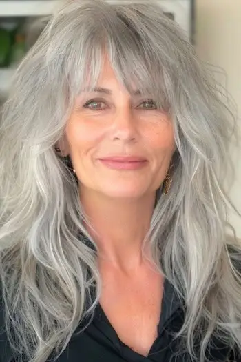 Dlouhý stříbrný účes pro ženy nad 60 let.