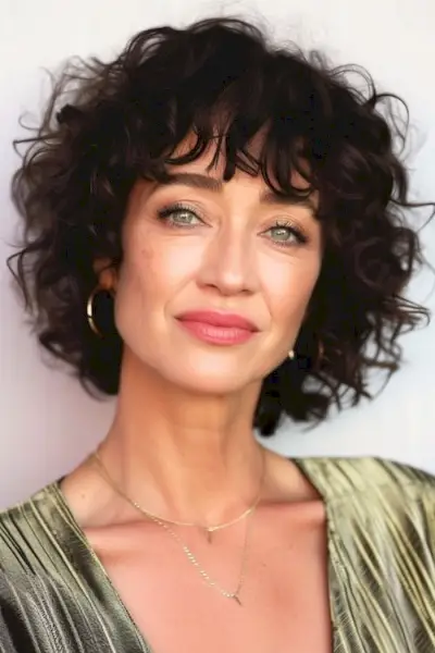 Buclele maro naturale spală și poartă coafura pentru femeile peste 60 de ani.