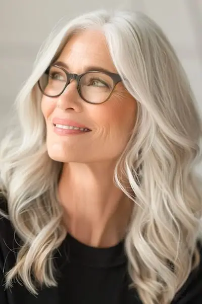 Peinado de ondas largas para mujeres mayores de 50 años con gafas.