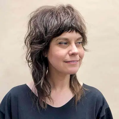 Medium Shag Shullet with razor cut layers and bangs for ladies over 40