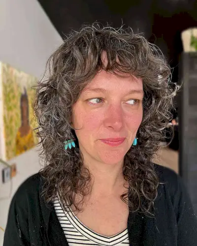 Mid-Length Brown Shag with Textured Curls and Bangs for Women Aged 40