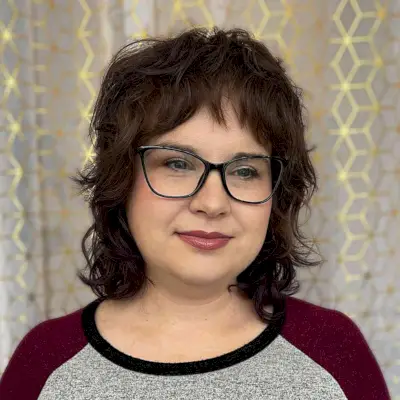 Shoulder-Length Shaggy-Mullet Style with Baby Bangs for Women Over 40 with Glasses