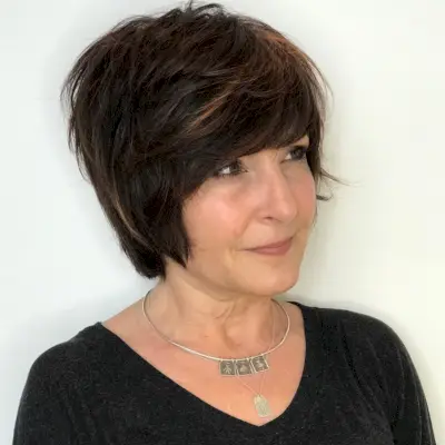 Long pixie with feathered layers for women over 50 with thick hair
