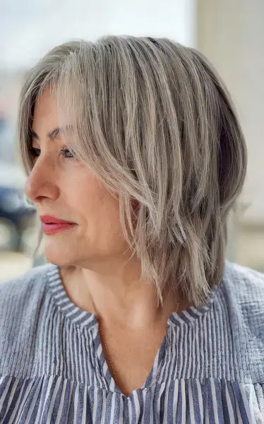 Shaggy layered bob with curtain bangs for women over fifty