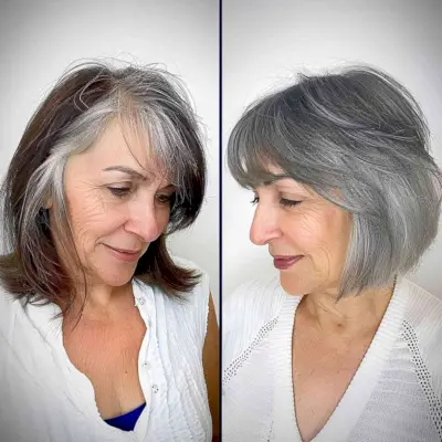 Sleek chin-length bob with bangs on grey hair for older women.