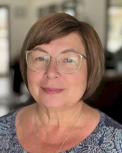 Sleek Bob with Side Bangs for 50-Year-Olds with Round Faces and Specs