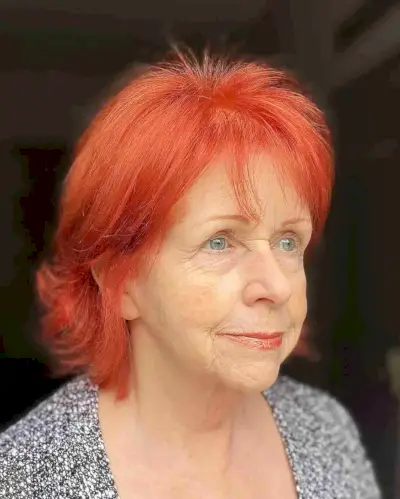 Bright Copper Red Hair with Wispy Bangs for Ladies in Their 70s