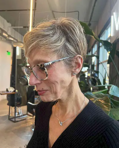 Short Side-Swept Pixie with Blonde Highlights for women past their 60s with glasses