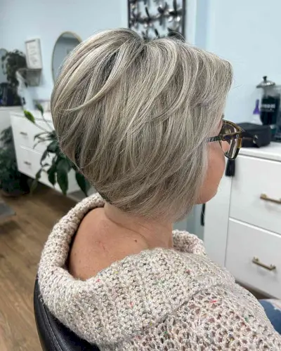 Feminine feathered bob with bangs for women over 50 with glasses