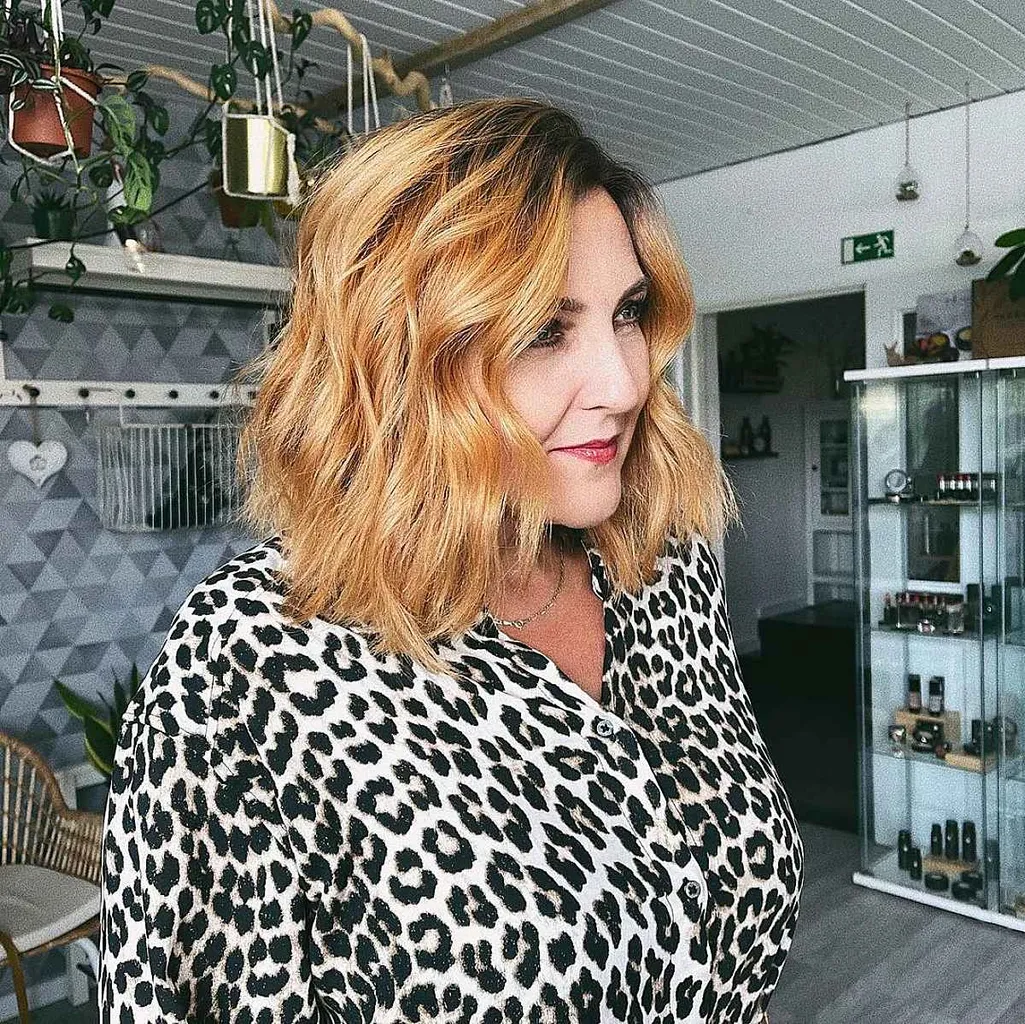 ミドルレングスのゴールデンブロンドのウェーブのヘアスタイル' title=