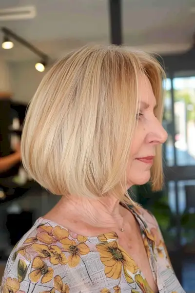 Neck-length blonde bob hairstyle for women over 60, featuring soft layers and sleek lines.