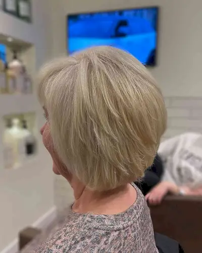 Neck-Grazing Sandy Blonde Feathered Inverted Bob with Wispy Layers for Seniors Over 60