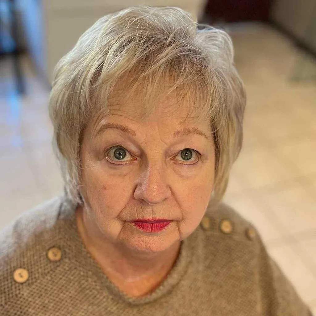 Měkké blond krátké vlasy s opeřenými vrstvami pro ženy nad 60 let s kulatým obličejem' title=