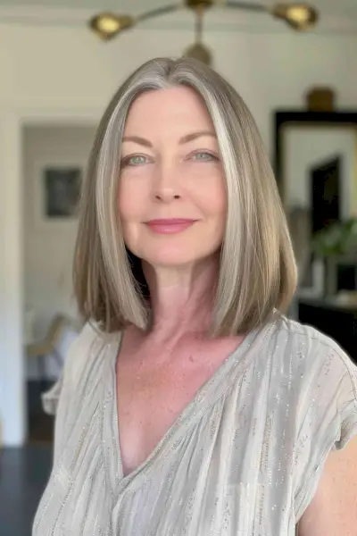 Woman with medium-length blunt bob, center part, and natural gray highlights.
