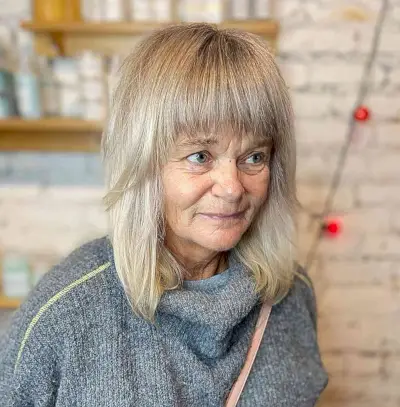 Foil Highlights on Mid-Length Blonde Hair with Bangs for women in their 60s