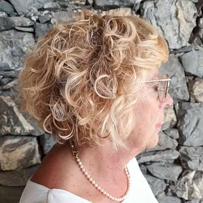 Jaw-Length Curly Inverted Bob with Bangs for Wash and Wear Women Over Fifty with Blonde Hair
