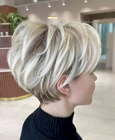 White Blonde Layered Pixie Bob with dark roots and a tapered nape