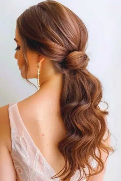 低いウェーブのかかったポニーテール プロムのヘアスタイルのアイデア、後ろから撮影。