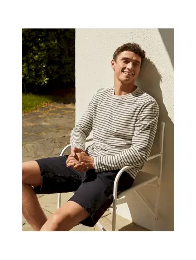 Das strahlende britische Model Matthew Holt trägt einen gestreiften Pullover und Jeansshorts von 8 by YOOX.