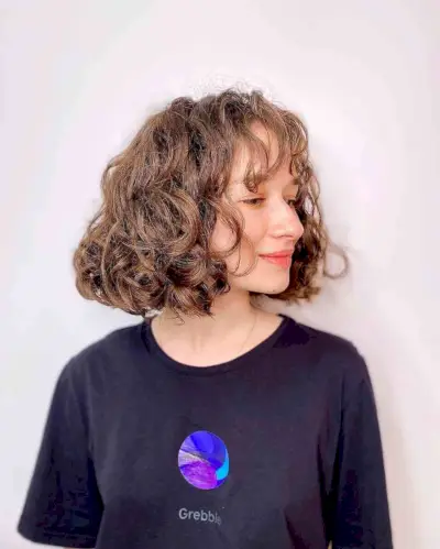 Short curly hairstyle with blunt bangs
