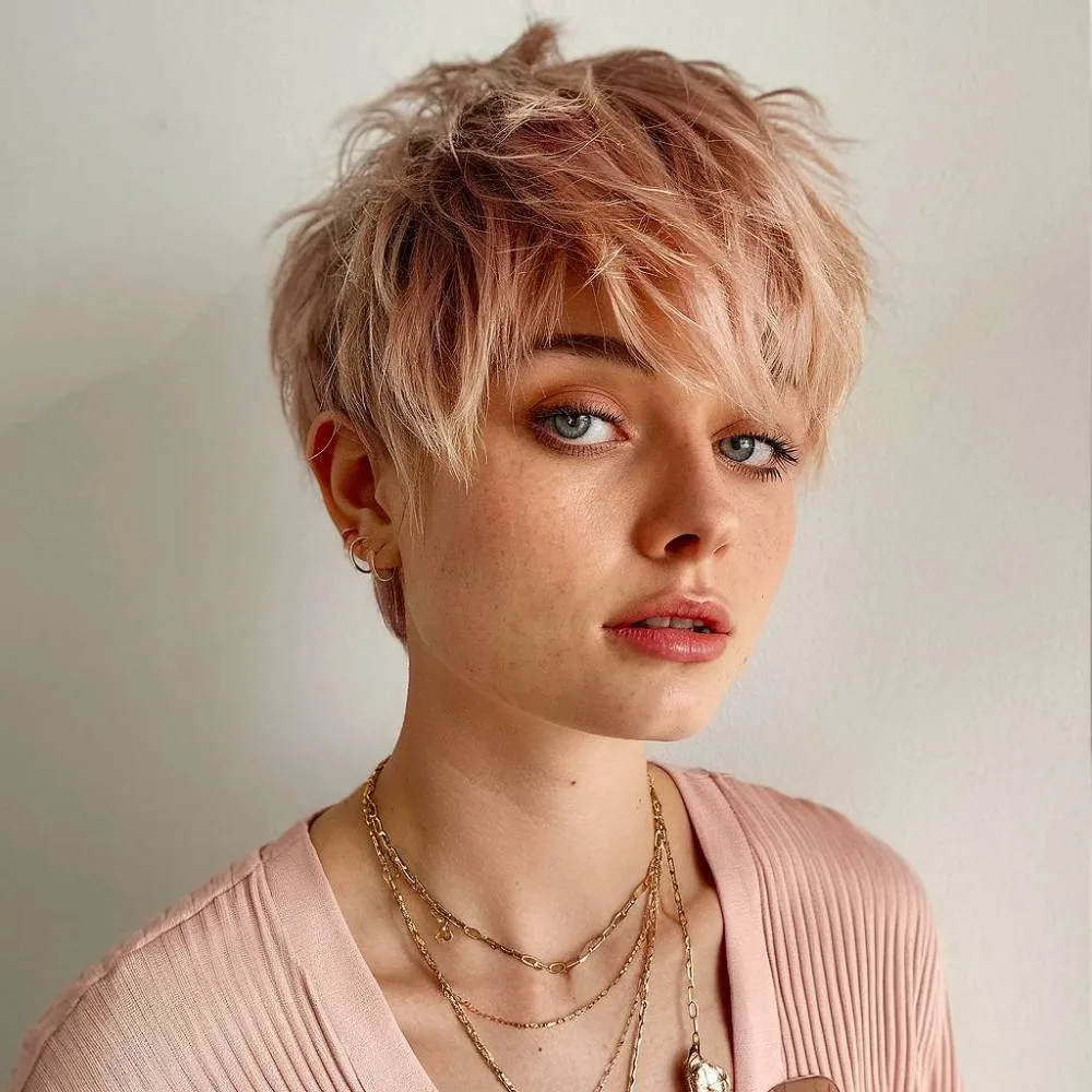 Corte pixie rosa suave com camadas de penas finas e textura desgrenhada para um penteado curto feminino moderno' title=