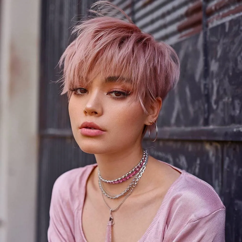 Croială pixie șic, roz pastel, cu straturi agitate și breton firav pentru o coafură scurtă modernă îndrăzneață' title=