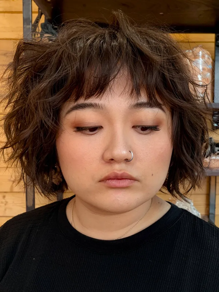 Taglio di capelli corto stile shag anni '70 con texture scalata per donne plus size' title=